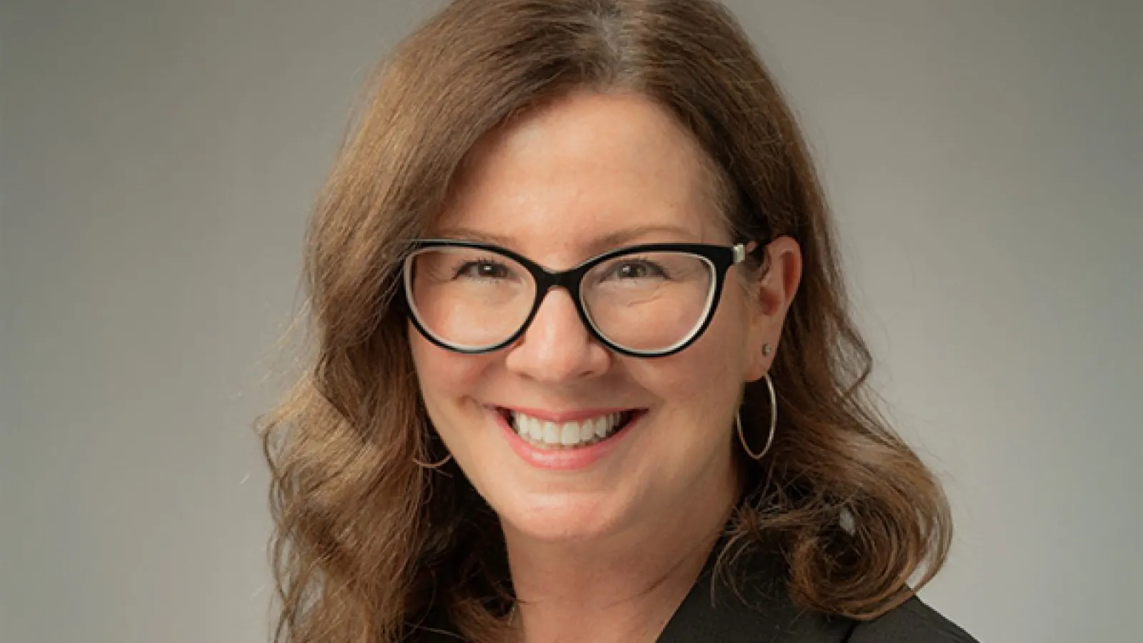 Smiling woman with long hair wearing glasses