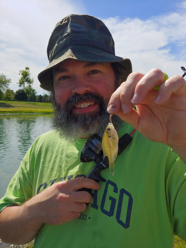 Dr. Moore holding a really small perch he caught fishing.
